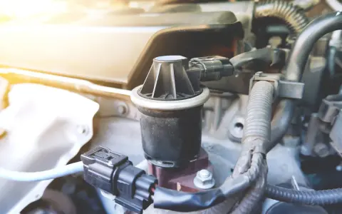 Componente egr, cos'è? Un pezzo del motore auto, con connettori elettrici e tubi.