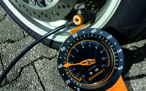Manometro Continental per pneumatici moto, collegato alla ruota. La lancetta indica la pressione.