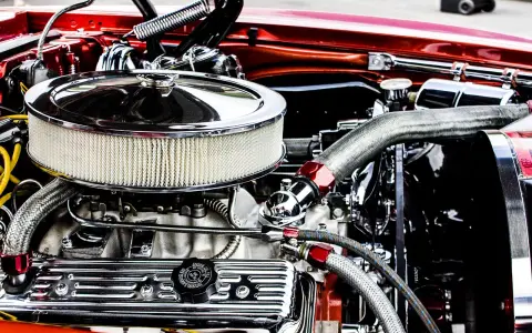 Motore cromato lucido, con filtro aria rotondo e tubi intrecciati. Un esempio di come si misurano i cavalli di un motore, con dettagli che ne esaltano la potenza.