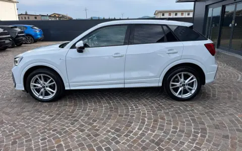 Audi Q2 bianca parcheggiata su pavé. Controlla la pressione pneumatici per un viaggio sicuro.