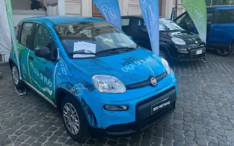 Una Fiat Panda blu con grafica "BIO HYBRID ORA SI PUÒ" e "BIO METANO". Un'auto ecologica che passa da metano a benzina da sola.