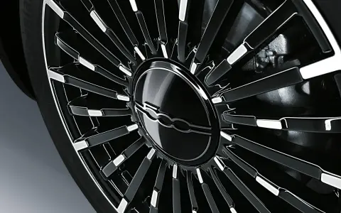 Cerchio in lega nero lucido con logo Fiat centrale, dettaglio per la pressione gomme Fiat 500L.