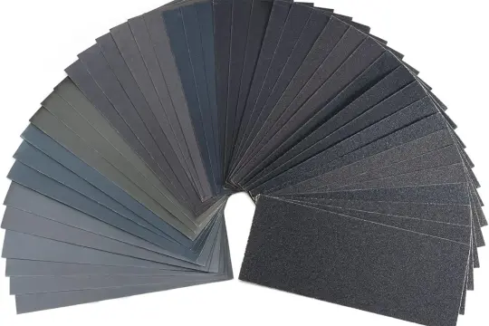 Un assortimento di fogli di carta vetrata in varie grane, utili per levigare e rifinire superfici.