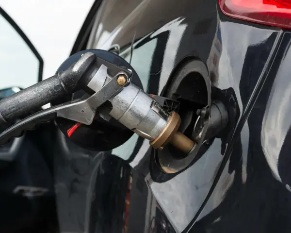 Ugello di rifornimento GPL inserito nel serbatoio di un'auto a benzina e GPL.