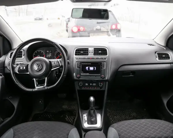 Interno di una Volkswagen Polo, con volante, cruscotto e cambio. Il display mostra il parcheggio assistito, utile per chi cerca il codice colore auto Volkswagen Polo.