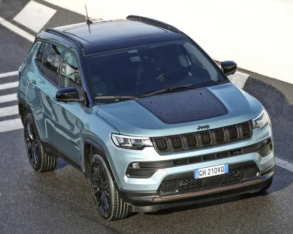 Jeep Compass color acqua con tetto nero, su strada con strisce bianche. La pressione pneumatici è ottimale per affrontare ogni percorso.