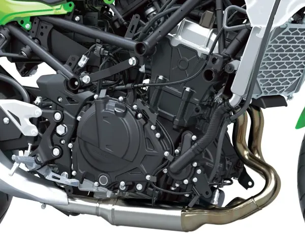 Dettaglio motore di una moto, con tubi di scarico lucidi e componenti meccanici complessi. Il freno motore è parte integrante di questo sistema.