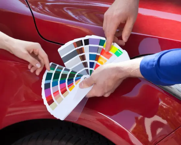 Mani scelgono colori da campionario per il costo ripristino trasparente auto.