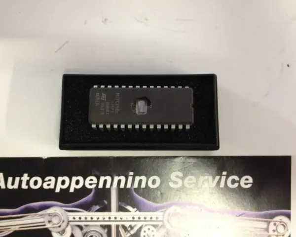 Eprom centralina M27C256B, un componente essenziale per il funzionamento di molti sistemi elettronici, qui in un contenitore protettivo.