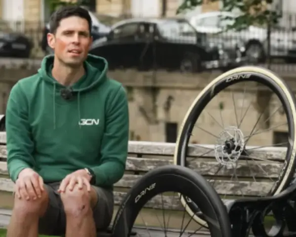 Ciclista con due ruote da bici, una più grande per maggiore velocità.