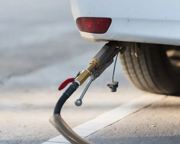 Rifornimento di un'auto a gas. Il tubo di erogazione è collegato all'attacco, pronto per il pieno. GPL e metano sono la stessa cosa per molti, ma non è così.