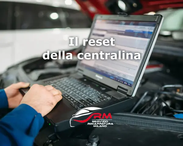 Tecnico esegue il reset centralina auto con laptop. Il logo RM Servizio Rimappatura Milano è visibile.