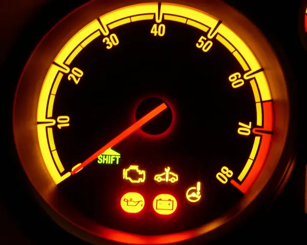 Cruscotto Opel Corsa con spie accese: olio, batteria, motore e sterzo. L'ago del contagiri è fermo.