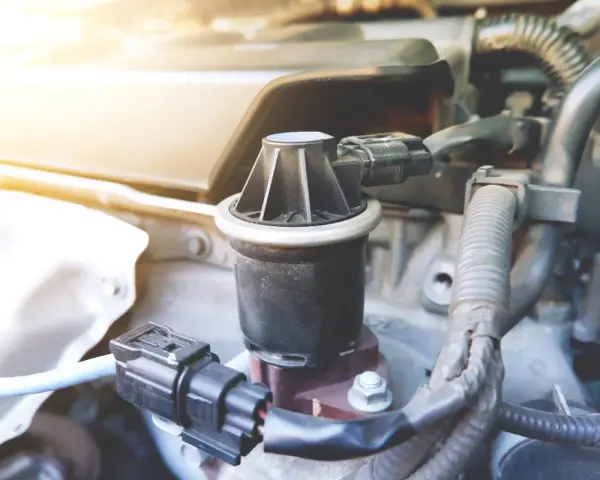 Componente egr, cos'è? Un pezzo del motore auto, con connettori elettrici e tubi.
