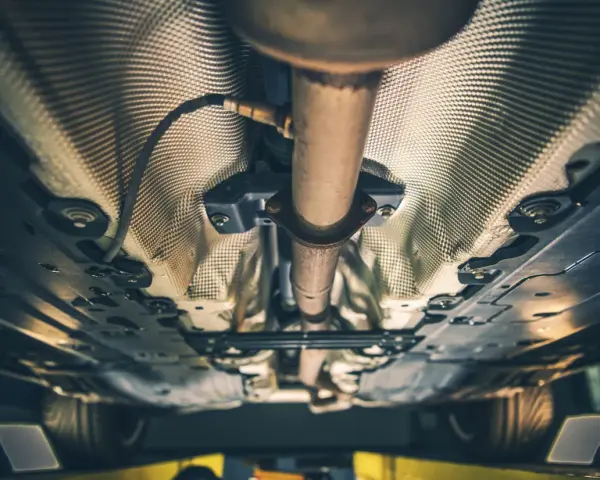 Sottoscocca di un'auto diesel con sistema di scarico e isolamento termico. Si percepisce la potenza dei vuoti in accelerazione.