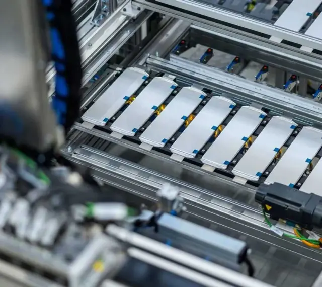 Linea di produzione per lo smaltimento batterie auto elettriche. Moduli batteria disposti su un nastro trasportatore.