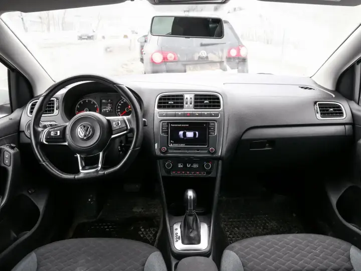 Interno di una Volkswagen Polo, con volante, cruscotto e cambio. Il display mostra il parcheggio assistito, utile per chi cerca il codice colore auto Volkswagen Polo.
