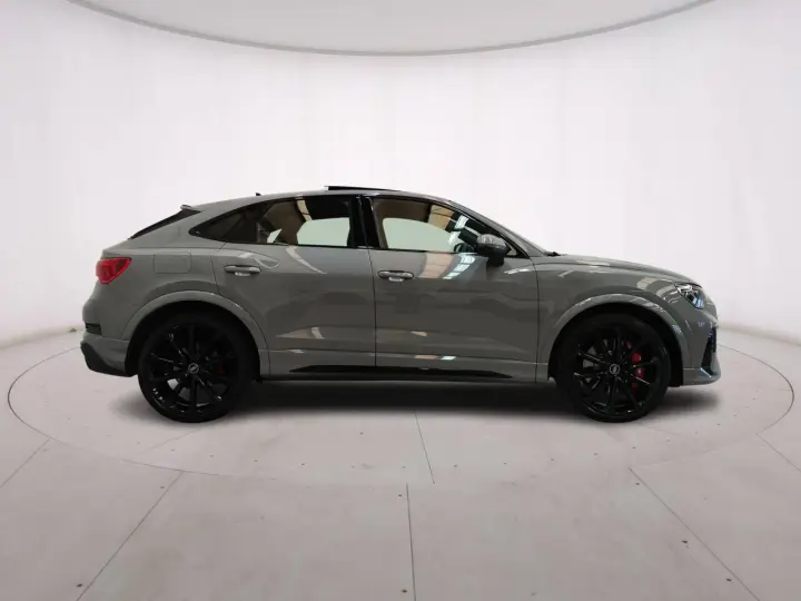 Audi RS Q3 Sportback in grigio nardo, con cerchi neri e pinze rosse. Un SUV coupé elegante e sportivo.