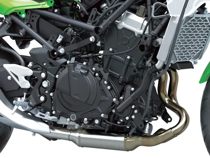 Dettaglio motore di una moto, con tubi di scarico lucidi e componenti meccanici complessi. Il freno motore è parte integrante di questo sistema.