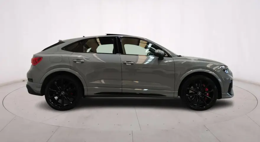 Audi RS Q3 Sportback in grigio nardo, con cerchi neri e pinze rosse. Un SUV coupé elegante e sportivo.