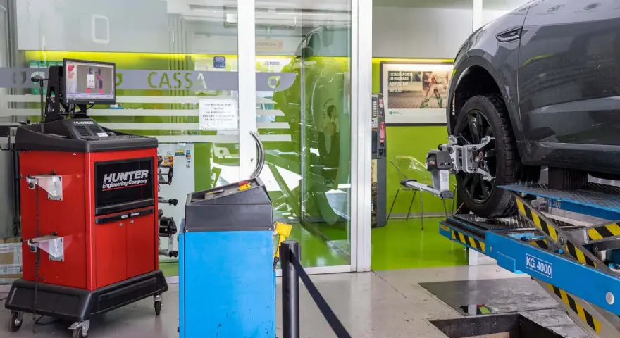 Officina con banco convergenza Hunter e auto su ponte sollevatore. Se noti **auto fuori convergenza sintomi**, qui puoi risolvere.