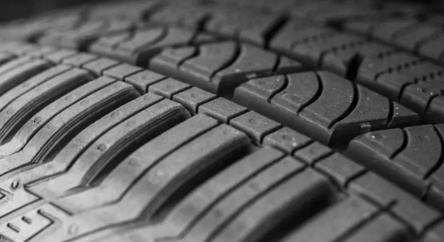 Primo piano del battistrada di un pneumatico, con le scanalature che garantiscono aderenza e stabilità per una guida sicura ad alta velocita.