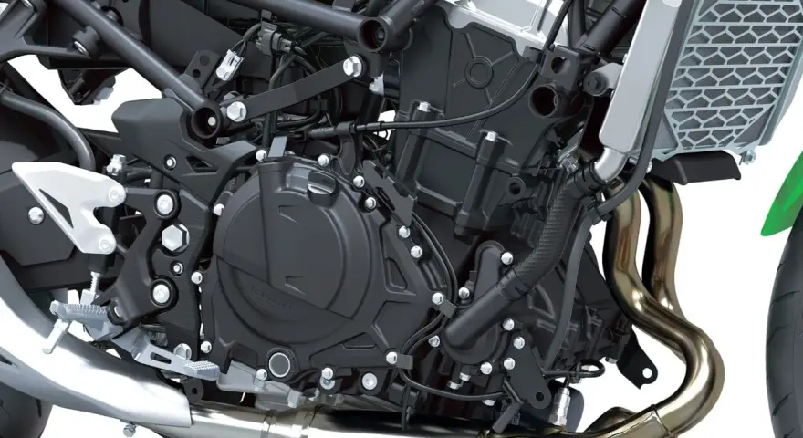 Dettaglio motore di una moto, con tubi di scarico lucidi e componenti meccanici complessi. Il freno motore è parte integrante di questo sistema.