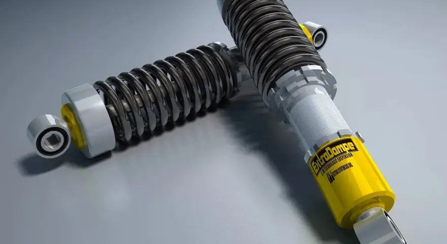 Due ammortizzatori auto di alta qualità, uno giallo con logo "ExtraDampe", pronti a migliorare le prestazioni su strada.
