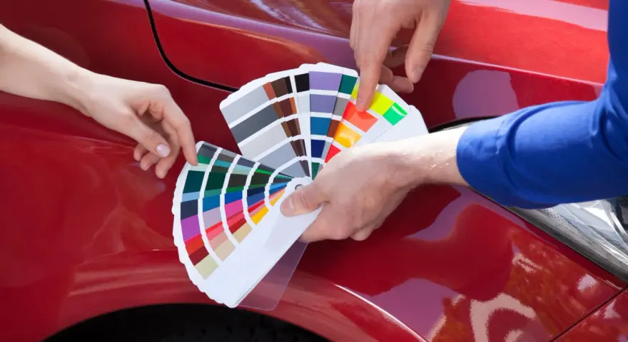 Mani scelgono colori da campionario per il costo ripristino trasparente auto.