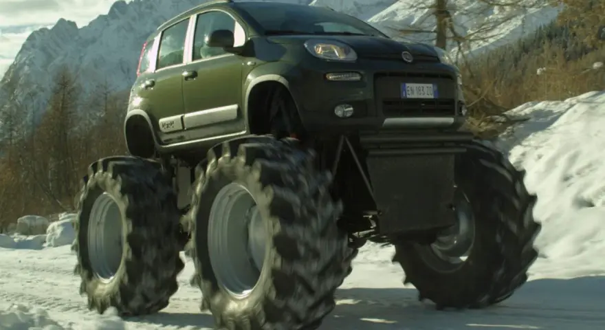 Un'auto verde con enormi gomme da trattore su un terreno innevato. Sembra che si possa montare gomme da 17 su cerchi da 16 per un look così estremo.