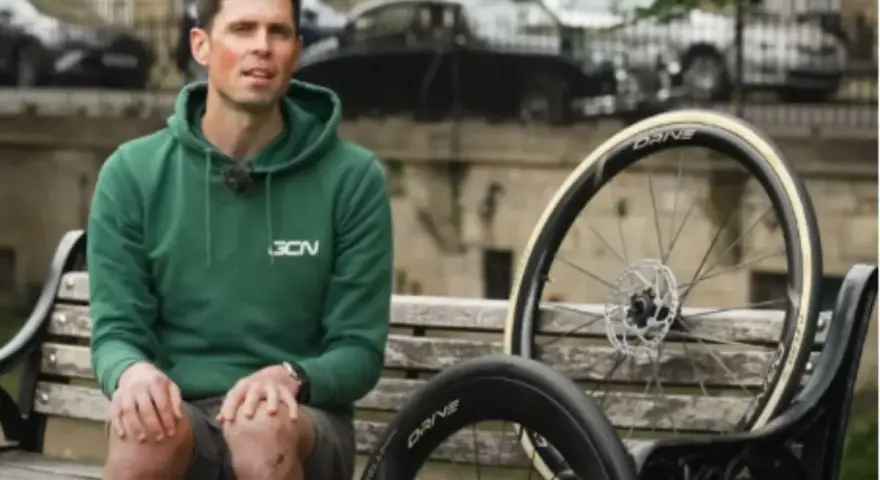 Ciclista con due ruote da bici, una più grande per maggiore velocità.
