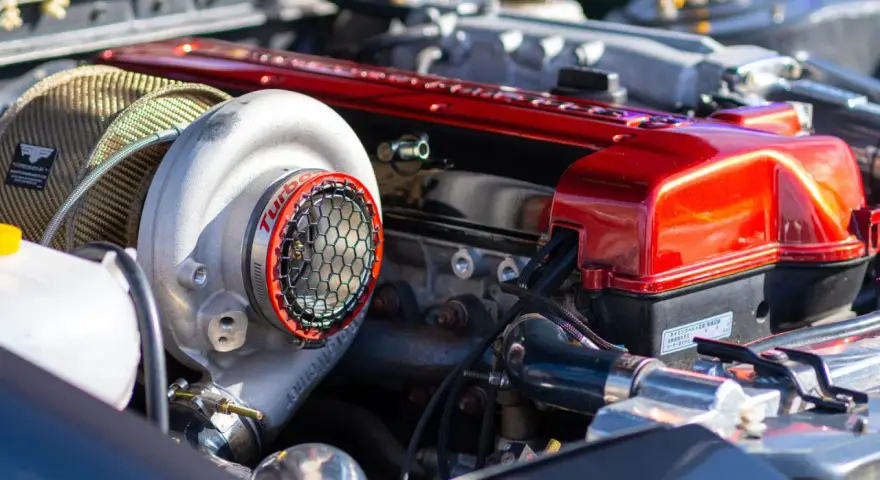 Motore con turbocompressore cromato e coperchio valvole rosso lucido. La differenza tra motore aspirato e turbo è evidente in questa immagine.