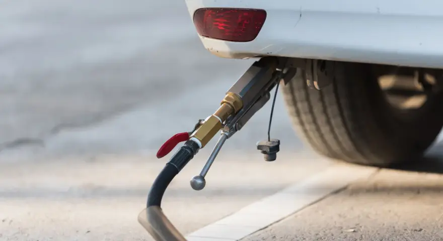 Rifornimento di un'auto a gas. Il tubo di erogazione è collegato all'attacco, pronto per il pieno. GPL e metano sono la stessa cosa per molti, ma non è così.