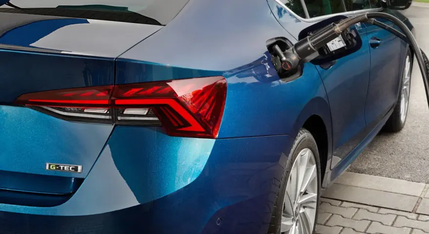 Rifornimento di un'auto blu con motore a metano. La pompa è inserita nel serbatoio.