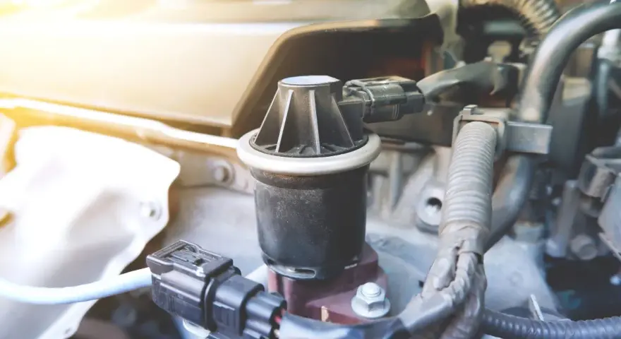 Componente egr, cos'è? Un pezzo del motore auto, con connettori elettrici e tubi.