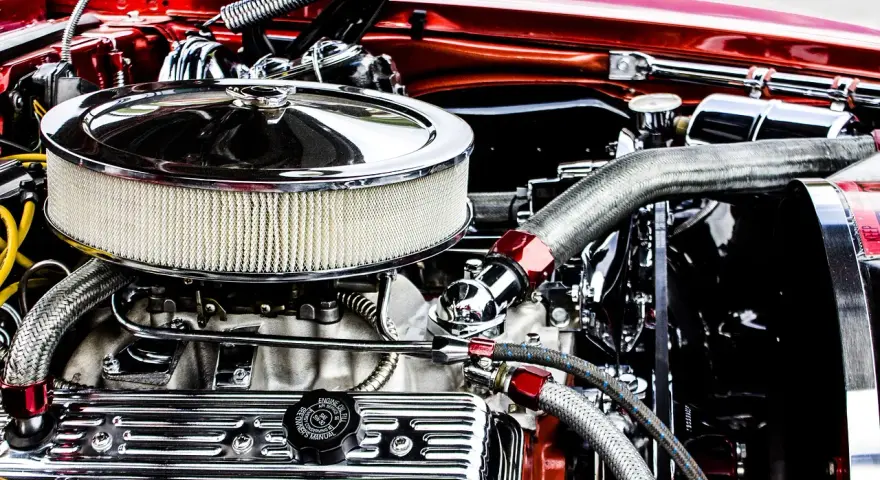 Motore cromato lucido, con filtro aria rotondo e tubi intrecciati. Un esempio di come si misurano i cavalli di un motore, con dettagli che ne esaltano la potenza.