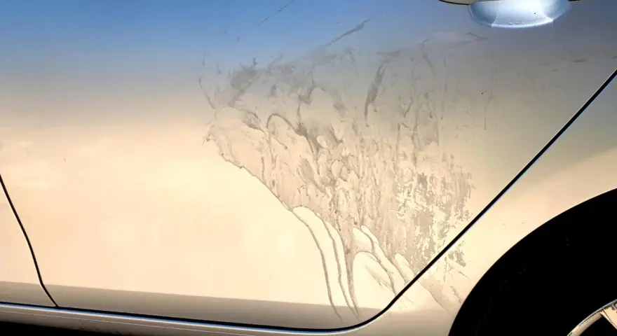 Sporco e macchie sul fianco di un'auto argentata, forse dopo un trattamento di soda blasting.