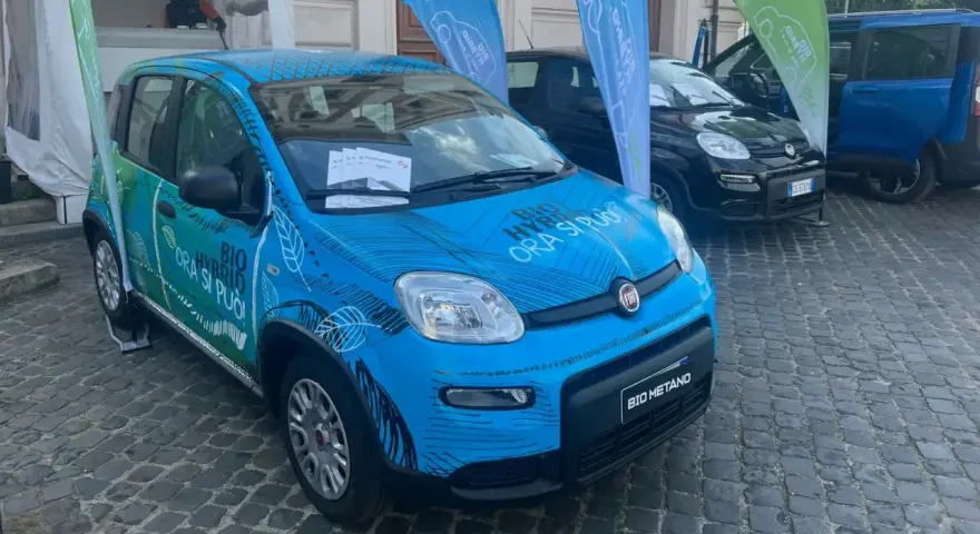 Una Fiat Panda blu con grafica "BIO HYBRID ORA SI PUÒ" e "BIO METANO". Un'auto ecologica che passa da metano a benzina da sola.