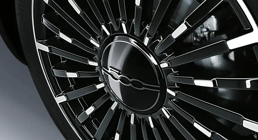 Cerchio in lega nero lucido con logo Fiat centrale, dettaglio per la pressione gomme Fiat 500L.