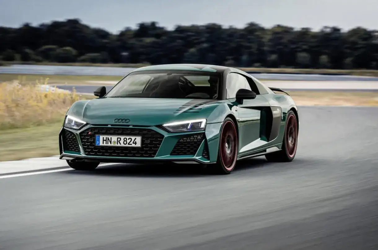 Audi R8 verde su pista, un'auto con motore aspirato che sfreccia con stile.