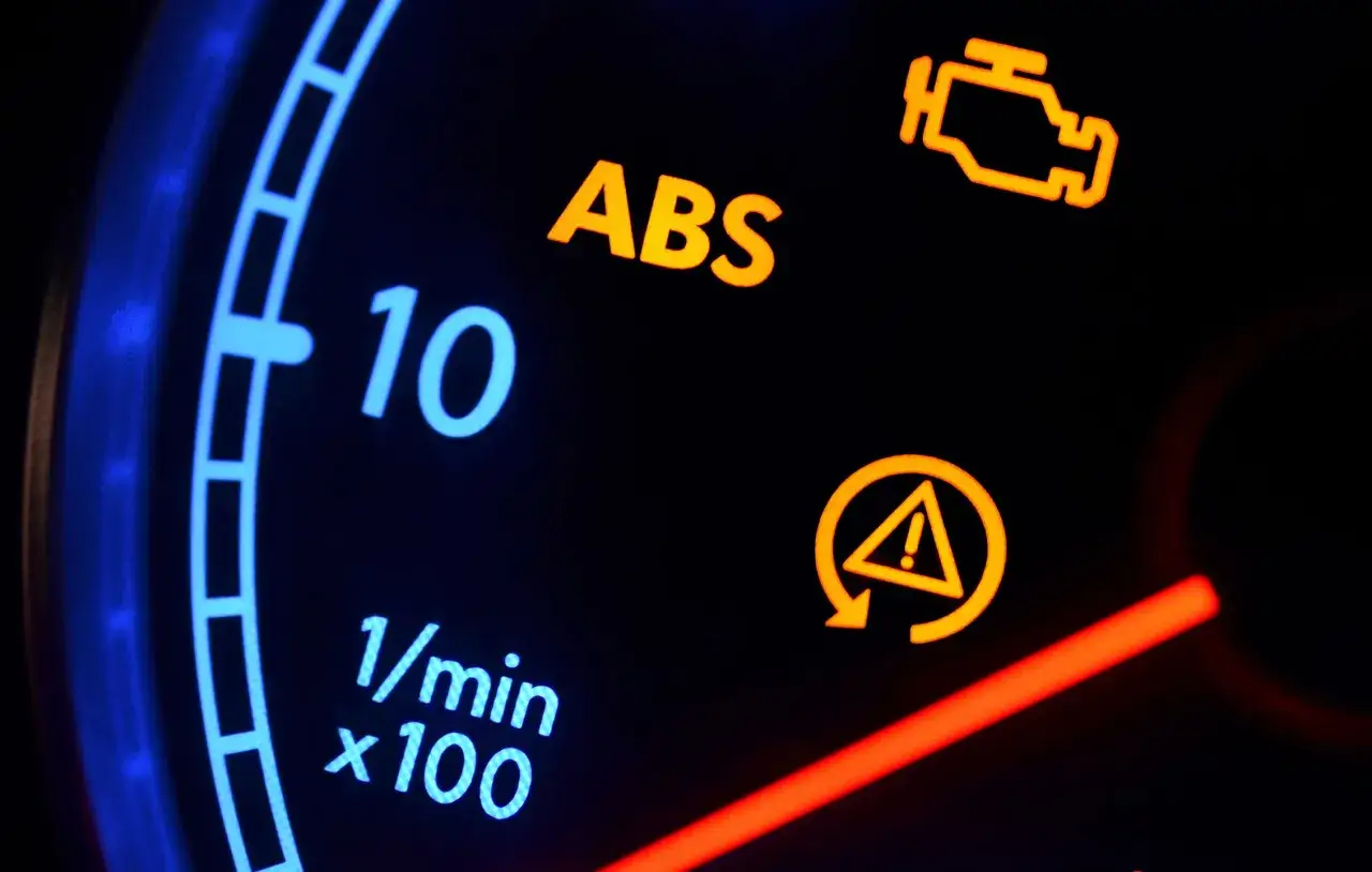 Cruscotto auto con spie accese: ABS, controllo motore e avaria. Indica un problema con il sistema frenante antibloccaggio.