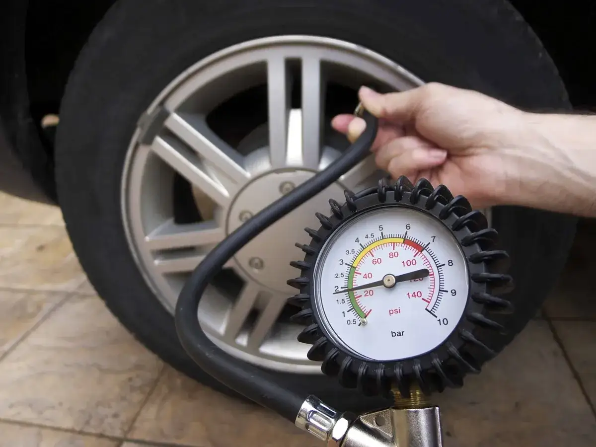 Controllo pressione pneumatici 195/55 r16 con manometro. La lancetta indica il valore corretto.
