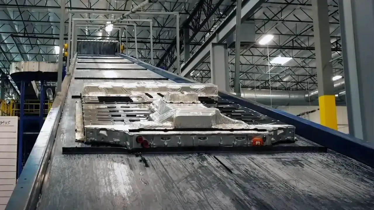 Batterie per auto elettriche su un nastro trasportatore, pronte per lo smaltimento e il riciclo.