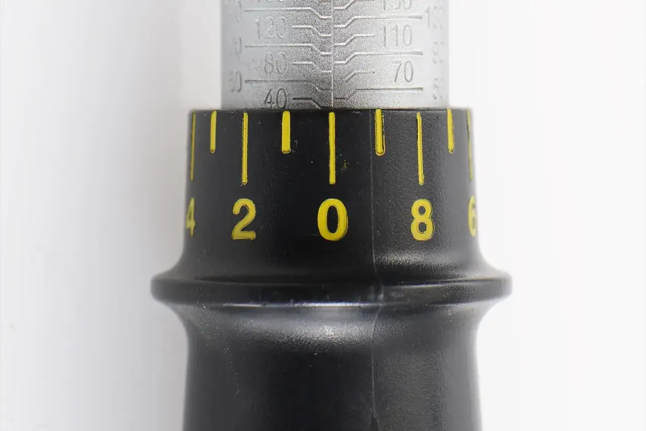 Dettaglio di una chiave dinamometrica con scala graduata. La ghiera nera presenta numeri gialli (2, 0, 8) e tacche, indicando il valore di serraggio in Nm.
